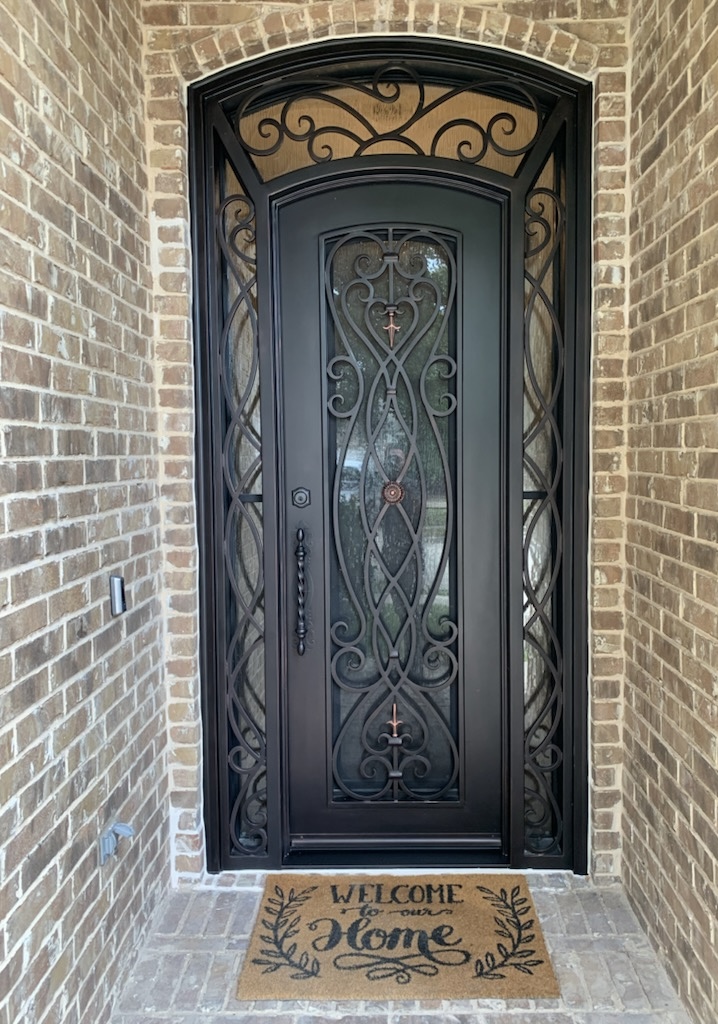 Ornate black front door with welcome mat